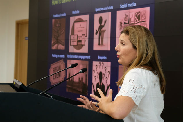 Woman in white blouse presenting on the podium.
