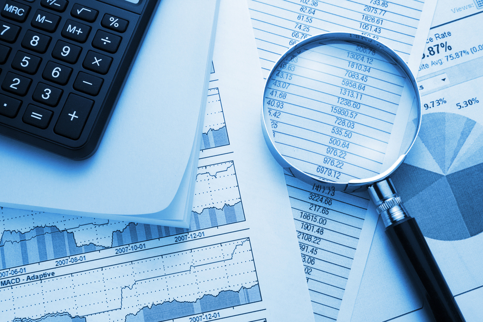Calculator, papers with statistics and a magnifier tool.