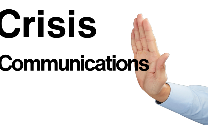 Crisis communications black text on white background with hand leaning against the word communications