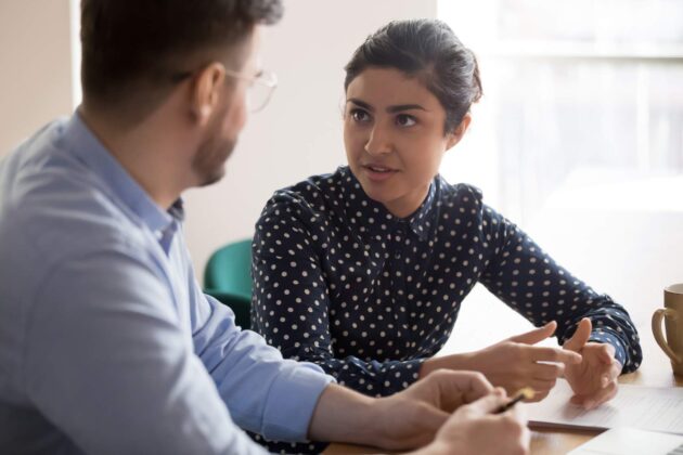 A photograph of a woman speaking to a colleague about her career.