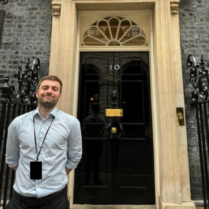 Close-up of Marcus Melton stood in front of the 10 Downing Street front door.