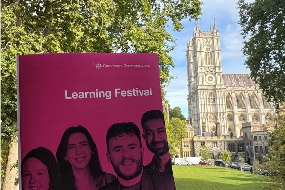 Image showing Westminster Abbey in background and pink Learning Festival brochure in the foreground