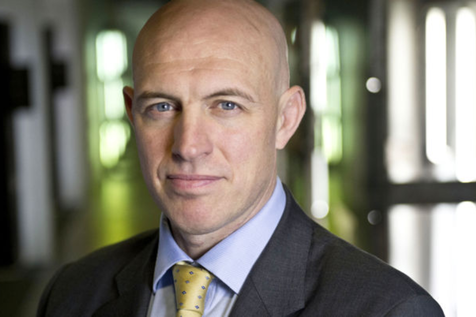David Dinsmore, new Permanent Secretary Director of Government Communications looking towards the camera. This is a portrait-style image of David's head and shoulders, and the background is blurred.