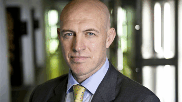 David Dinsmore, new Permanent Secretary Director of Government Communications looking towards the camera. This is a portrait-style image of David's head and shoulders, and the background is blurred.