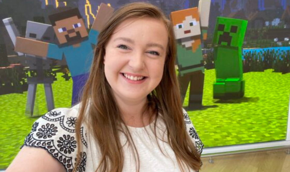 A selfie of Abby Wade in front of a Minecraft poster.