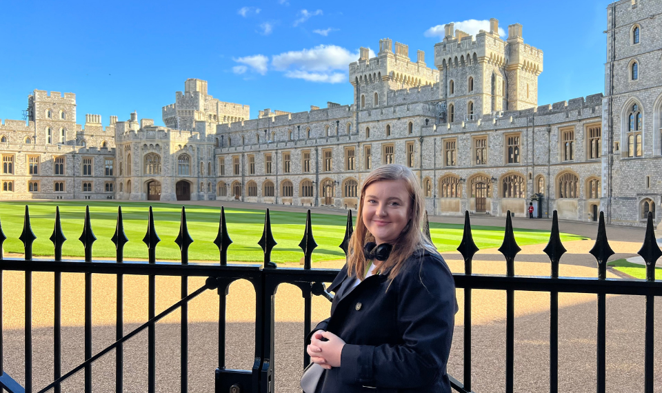 Abby Wade in front of a large historical building with a black spiked fence.