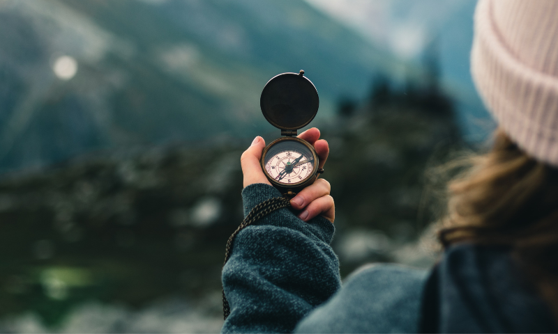 A person holds up a compass.