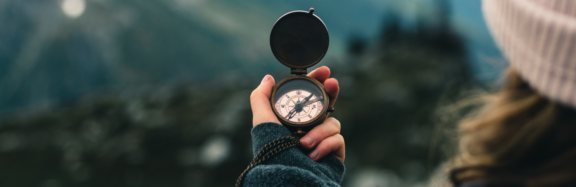 A person holds up a compass.
