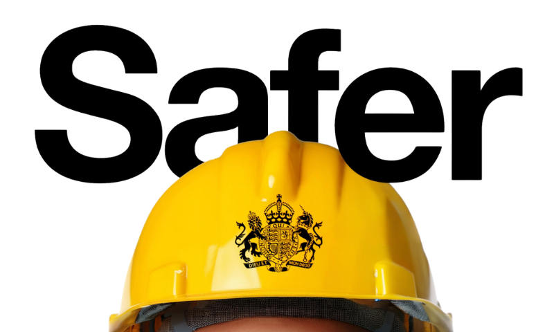 The top of a yellow hard hat with the UK Government coat of arms in the centre and the word 'Safer' positioned on top, against a white background.